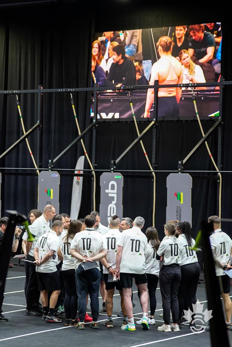 The officials' team briefed in a circle beneath the arena screen